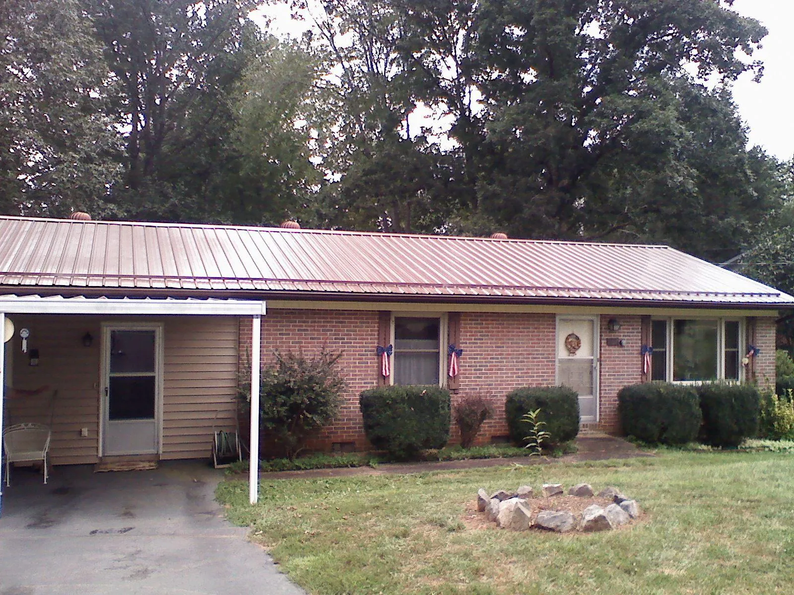 Bronze metal roof and carport on a brick ranch home — Roof Repair work by our crew in Westcliffe